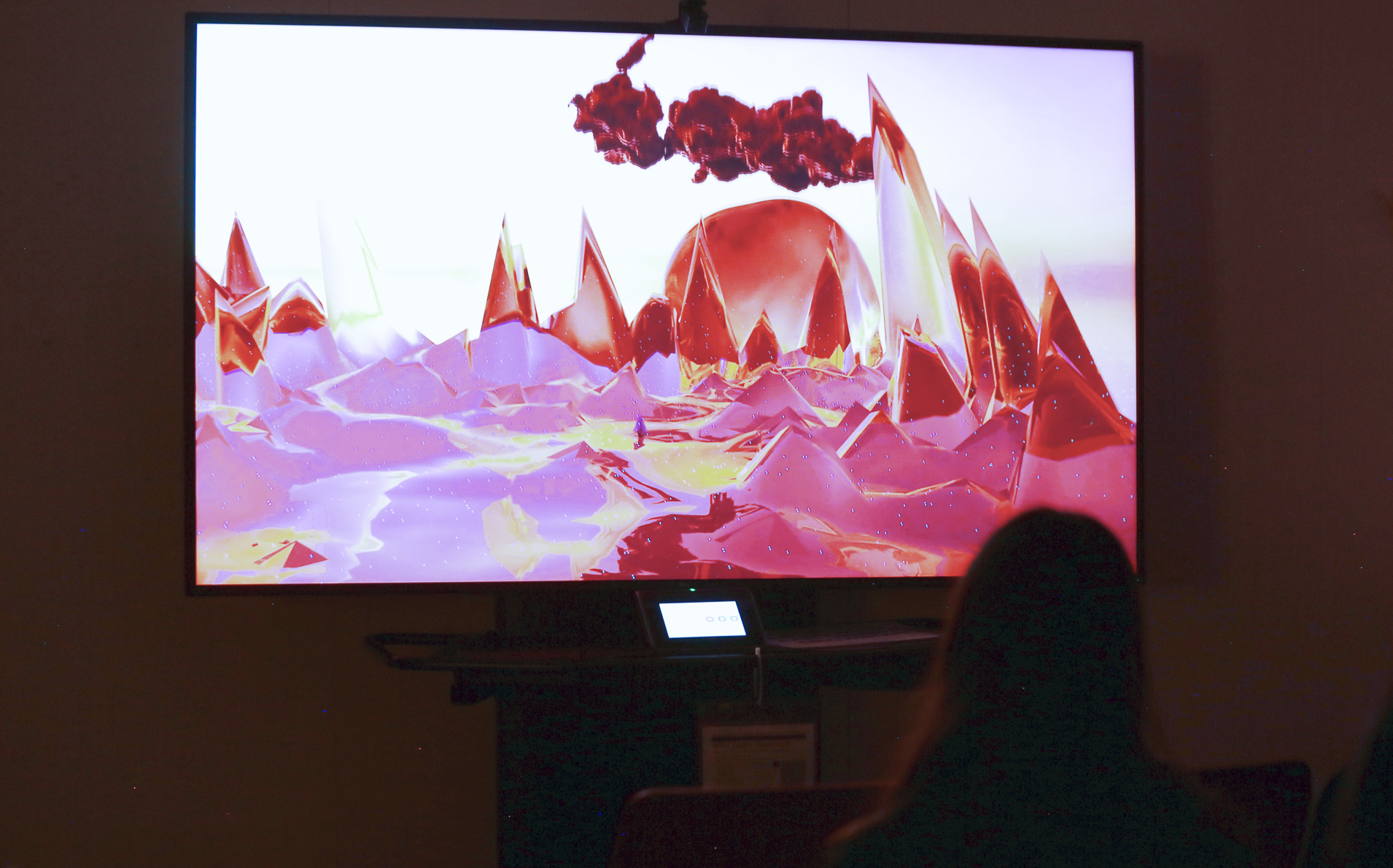 A television screen in a darkened room showing a digitally generated landscape